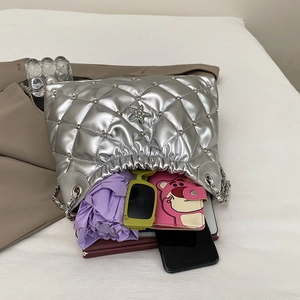 Silver quilted bucket bag with star charm and chain strap showing large interior capacity