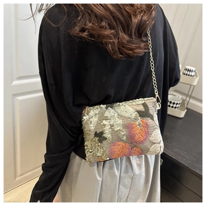 Détail des broderies à paillettes et de la bandoulière chaîne dorée sur ce sac à main