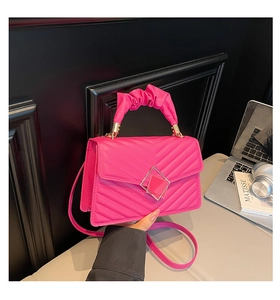Detail view of hot pink quilted square bag with pleated handle and metal buckle