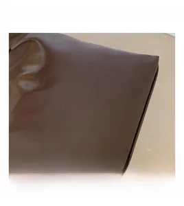 Detail view of smooth dark brown leather tote bag featuring white FASHION lettering