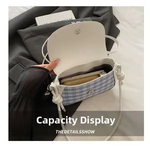Détails de la capacité du mini sac à carreaux bleus montrant téléphone et portefeuille