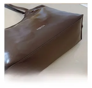 Detailed close-up of precise stitching and smooth brown finish on a large tote bag