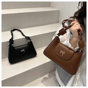 Detail of woven leather handles and silver bow buckles on retro underarm bags