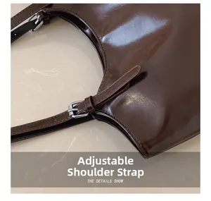 Detail of adjustable strap with silver buckle on dark brown glossy leather tote bag