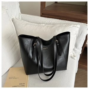 Detail der schwarzen Shopper-Tasche aus Kunstleder mit goldener Aufschrift