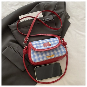 Vue détaillée du sac bandoulière rouge avec rabat vichy bleu et broderie de pomme