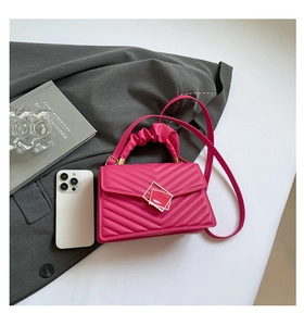 Detailed view of quilted rose red faux leather bag with stylish gathered handle
