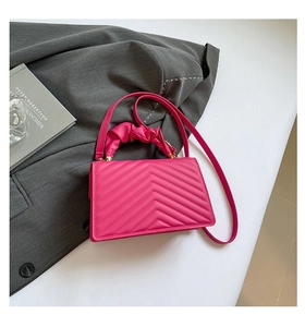 Detail of rose pink quilted PU bag with scrunchie handle and gold hardware accents