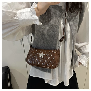 Detail of dark brown patent leather shoulder bag with quilted studs and star emblem