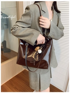 Dark coffee patent leather tote bag with white lettering and baseball charm detail