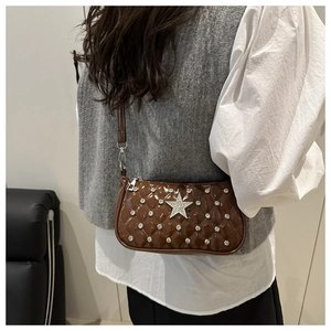 Detail of brown patent leather hobo bag with quilted diamond pattern and star rhinestone