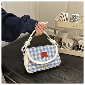 Détail du sac à main à carreaux bleus et blancs avec broderie pomme rouge et anse nouée