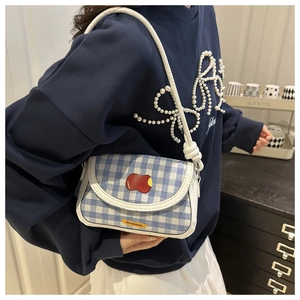 Détail du mini sac bandoulière à carreaux bleus avec broderie pomme et bandoulière nouée