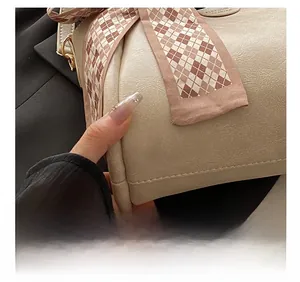 Close-up of precise stitching and corner reinforced leather on the cream bucket bag