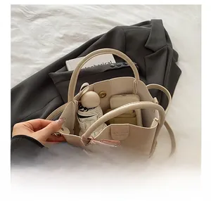 Detail showing high capacity of beige tote bag with umbrella and phone inside