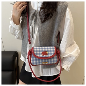 Détail du mini sac bandoulière à carreaux bleu et blanc avec patch pomme rouge