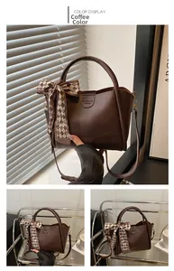 Close-up of a dark coffee bucket bag with a checkered silk scarf on the handle