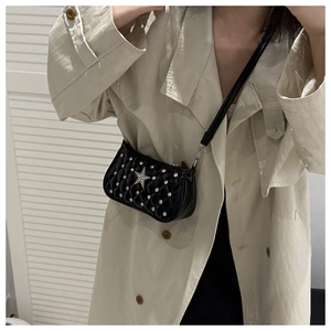 Close-up of black quilted shoulder bag with rhinestones and silver star detail