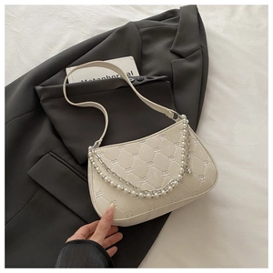 Détail du sac crème avec broderie flocon de neige, perles et chaînes métalliques