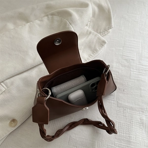 Retro brown leather underarm bag with braided strap and internal storage view