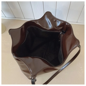 Detail view of large brown tote bag showing black zipper pocket and spacious interior