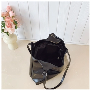 Top view of large glossy black tote bag interior showing spacious compartments and zipper pocket