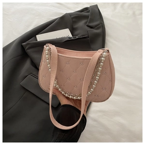 Détail du sac hobo rose matelassé avec gaufrage nœud et chaîne en métal perlé
