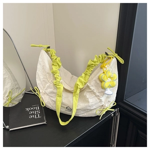 Detail of off-white nylon crescent bag with neon green pleated strap and flower charm