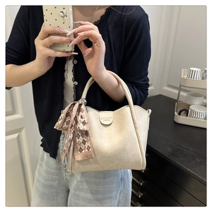Detail of beige bucket bag with decorative silk scarf and JINGPIN fashion logo