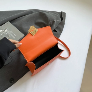 Orange quilted flap bag with golden buckle and adjustable shoulder strap for women