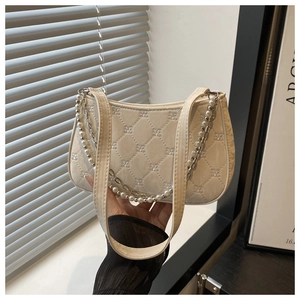 Detail of cream white quilted crossbody bag with decorative pearl chain and embroidery