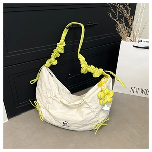Detail of white nylon crescent bag with yellow ruched strap and sunflower charm