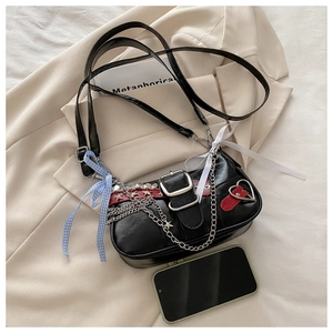 Détail du sac en cuir PU noir avec chaînes argentées et rivets en forme d'étoile