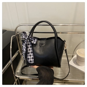 Detail of black leather bucket bag with silk scarf decoration and Jingpin embossed logo