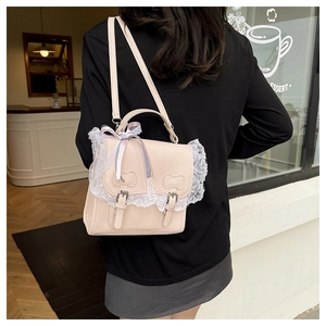 Detail of light beige PU leather backpack with lace trim and bow accents on back