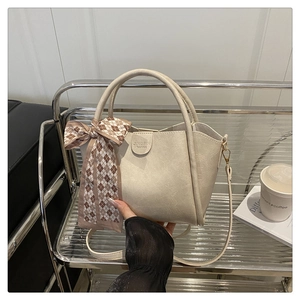 Detail of cream leather bucket bag with plaid silk scarf and JINGPIN fashion logo