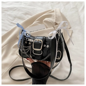 Détail du sac punk noir avec chaînes argentées, rivets étoiles et nœuds en soie