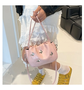 Pink pleated bucket bag with silver butterfly details styled with an edgy white lace outfit