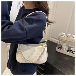 Détail du sac matelassé crème brodé avec bandoulières perles et chaînes argentées