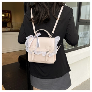Detail of cream backpack with delicate white lace trim and embossed bow patterns
