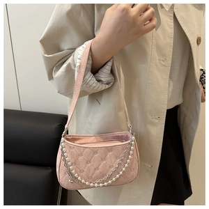 Detail of light pink quilted shoulder bag featuring pearl and metal double chain straps