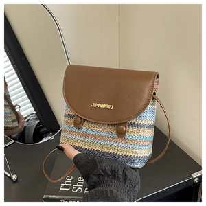 Detail showing the colorful woven stripes and brown leather flap of the bucket bag