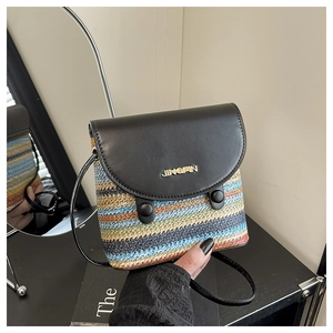 Detail of hand-woven colorful striped bucket bag with black leather flap and metal logo