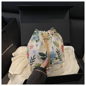 Détail du sac seau en jacquard floral avec cordon perle et chaîne dorée en coffret cadeau