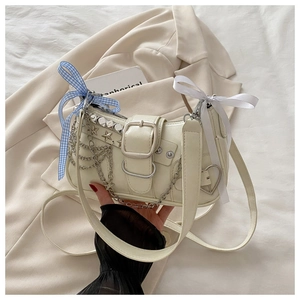 Détail du sac bandoulière en cuir PU crème avec clous étoiles argentés et chaînette