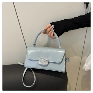 Detailed view of glossy light blue square handbag with sparkling crystal G buckle lock