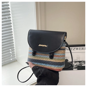 Detailed shot of rainbow woven mini bag with black leather lid and golden logo