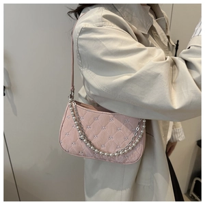 Détail du sac porté épaule rose matelassé avec chaîne perles et texture brodée