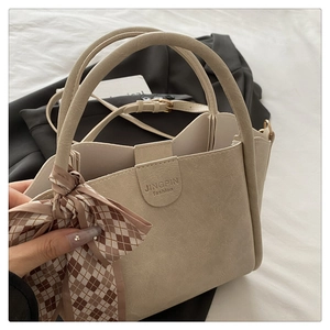 Detailed macro of beige bucket bag texture with elegant silk scarf and embossed logo