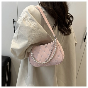 Détail du sac à bandoulière matelassé rose clair avec chaîne argentée et perles